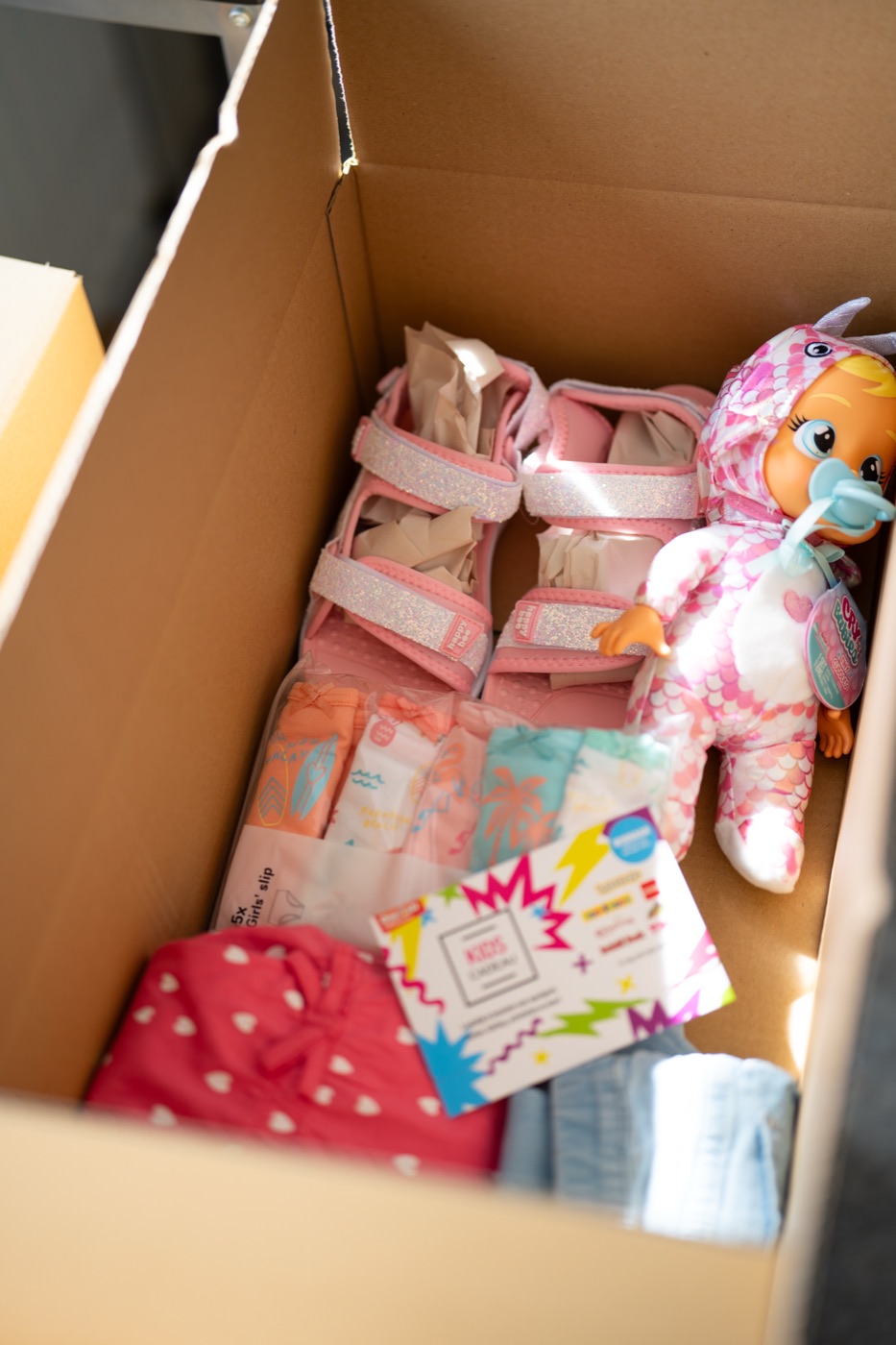 De inhoud van een SKKIN-pakket: nieuwe schoenen, kleding, speelgoed en een cadeaubon